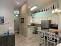 Modern kitchen featuring stainless steel appliances, an island with bar seating, and decorative bottles at 4208 Central Sarasota Pkwy # 1422, Sarasota, FL 34238