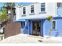 Inviting entrance to a cottage with a charming blue facade and wooden accents at 433 N Osprey Ave, Sarasota, FL 34236