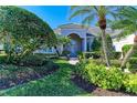 Charming front exterior highlighted by lush landscaping, palm trees, and a welcoming entryway at 5224 88Th E St, Bradenton, FL 34211