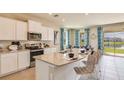 This modern kitchen features stainless steel appliances, granite countertops, and stylish seating at the breakfast bar at 5632 Silver Moonlight Dr, Palmetto, FL 34221