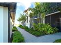 Attractive condo exterior featuring a brick pathway, complemented by green shrubs and vibrant tropical landscaping at 5685 Palmer Cir # 202, Bradenton, FL 34211