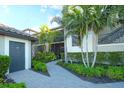 Charming exterior of a condo with lush landscaping, a brick path, and a convenient storage area by the front door at 5685 Palmer Cir # 202, Bradenton, FL 34211