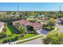 Beautiful home with mature landscaping, brick driveway, tile roof and a water view from behind at 6600 Horned Owl Pl, Sarasota, FL 34241