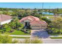 Aerial view of home with mature landscaping, brick driveway, tile roof and nearby community park at 6600 Horned Owl Pl, Sarasota, FL 34241