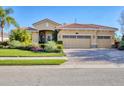 Well-maintained single-story home with a tile roof, brick driveway, and lush front yard at 6600 Horned Owl Pl, Sarasota, FL 34241