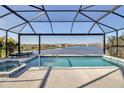 Screened-in pool and hot tub overlooking a serene lake with fountain and beautiful neighborhood views at 8726 Backshore Ln, Parrish, FL 34219