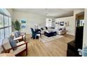 Bright living room featuring a ceiling fan, hardwood floors, and a comfortable seating area with natural light at 11371 Perico Isle Cir, Bradenton, FL 34209