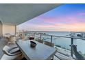 Relaxing balcony with a table and chairs, perfect for enjoying the beautiful water views at sunset at 1155 N Gulfstream Ave # 1205, Sarasota, FL 34236