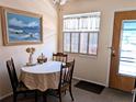 Cozy dining area with round table, three chairs, a painting, and natural light streaming through the window at 1531 Pleasant Rd # H-3, Bradenton, FL 34207
