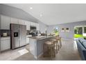 Modern kitchen with stainless steel appliances, granite countertop island and bar stool seating overlooking the living space at 16267 Banyan Ave, Port Charlotte, FL 33954