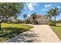 Charming two-story home with brick-paved driveway leading to attached garage, surrounded by lush landscaping at 17809 Howling Wolf Run, Parrish, FL 34219