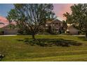 Stunning two-story home with lush green lawn, mature trees, and a charming front porch at 17809 Howling Wolf Run, Parrish, FL 34219
