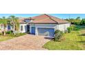 Attractive single-story home with a brick driveway leading to a two-car garage and well-maintained landscaping at 18115 Littleton Pl, Bradenton, FL 34202