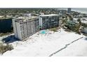 Aerial view of beachfront condos with swimming pool, beach access, and nearby city skyline at 20 Whispering Sands Dr # 301, Sarasota, FL 34242