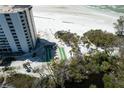 Aerial view of condo building on the beach with manicured landscape, bocce ball court and beach access at 20 Whispering Sands Dr # 301, Sarasota, FL 34242