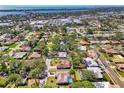Stunning aerial view of a neighborhood showcasing a single-story home surrounded by mature trees and lush landscaping at 2221 Pine View Cir, Sarasota, FL 34231