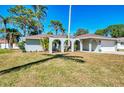 Lovely single-story home featuring an arched portico, well-maintained lawn, and an attached two-car garage at 2221 Pine View Cir, Sarasota, FL 34231
