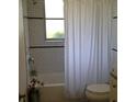 Bright bathroom featuring a shower with white subway tile, a sleek shower curtain, and a modern toilet at 22337 Olean Blvd, Port Charlotte, FL 33952