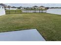 Expansive backyard featuring a tranquil pond view and fenced perimeter for privacy at 2409 Sand Gables Trl, Bradenton, FL 34208