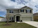 Inviting two-story home with a well-maintained lawn, and neutral color palette at 2409 Sand Gables Trl, Bradenton, FL 34208
