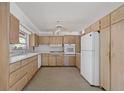 Functional kitchen featuring a white refrigerator, tile floors, and light wood cabinetry at 3466 Tanglewood Dr, Sarasota, FL 34239