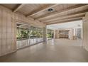 Open-concept living room with exposed beam ceiling, tile floors, and multiple sliding glass doors to the yard at 3466 Tanglewood Dr, Sarasota, FL 34239