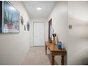 Bright hallway featuring neutral tile floors, a wooden console table, and closet space at 3502 18Th Avenue W Dr, Bradenton, FL 34205