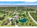 Expansive aerial view showcasing the property's mature landscaping, private pond, and surrounding acreage at 3551 Ridgeland Ct, Punta Gorda, FL 33982
