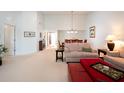 Bright living room with high ceilings, neutral colors, plush seating, and view of the dining room at 3922 Wilshire Cir # 177, Sarasota, FL 34238