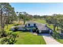 Beautiful two story home on a lush green lot with mature trees and golf course in the background at 4283 Southwell Way, Sarasota, FL 34241