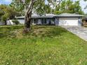 Charming single-story home features a well-manicured lawn, attached garage, and inviting curb appeal at 4453 Meadow Creek Cir, Sarasota, FL 34233