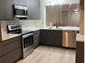 Modern kitchen featuring sleek cabinetry, stainless steel appliances, and a breakfast bar pass through at 4460 Fairways Blvd # 304, Bradenton, FL 34209