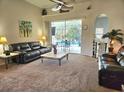 Cozy living room with plush seating, ceiling fan, and sliding glass doors that view the private pool area at 4464 Mcintosh Lake Ave, Sarasota, FL 34233