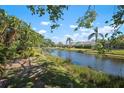 Beautiful waterfront view of canal, showing lush landscaping, blue skies and residences in the distance at 4464 Mcintosh Lake Ave, Sarasota, FL 34233