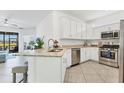 Kitchen featuring white cabinetry, granite countertops, stainless steel appliances, and an eat-in bar at 5311 White Sand Cv, Bradenton, FL 34211