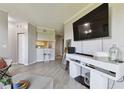 Comfortable living room featuring updated flooring and modern furniture with pass through to kitchen at 5401 Bentgrass Dr # 1-302, Sarasota, FL 34235