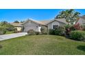 Well-maintained home with lush green lawn and mature landscaping offering privacy and curb appeal at 6017 Marella Dr, Sarasota, FL 34243