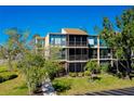 An aerial view of the condominium building exterior shows balconies and lush landscaping at 612 Bird Bay S Dr # 116, Venice, FL 34285