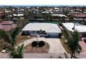 Aerial view of a waterfront property showcasing a tiled roof, circular driveway, and a canal at 618 Gladstone Ln, Holmes Beach, FL 34217