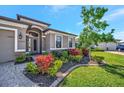 Landscaped front of the house features stone accents, colorful plants, and a well-maintained lawn at 6620 35Th E Ct, Sarasota, FL 34243