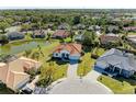 Stunning aerial view of a property with a red tile roof, surrounded by lush landscaping and a serene pond at 7102 42Nd E Ct, Sarasota, FL 34243