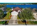 Aerial shot of single-story home near a lake and other homes, highlighting the community at 718 Tanana Fall Dr, Ruskin, FL 33570