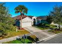 Well-kept single-story home with a two-car garage, lush lawn, and mature trees at 718 Tanana Fall Dr, Ruskin, FL 33570