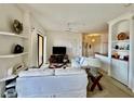 Comfortable living room with white sofa, ceiling fan, and built in shelving, perfect for relaxation and entertaining at 8397 38Th Street E Cir # 306, Sarasota, FL 34243