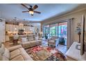 Bright living room featuring modern furniture, ceiling fan, and sliding glass doors leading to the pool area at 9902 Craftsman Park Way, Palmetto, FL 34221