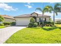 Charming single-story home featuring a tile roof, paved driveway, well-manicured lawn and beautiful landscaping at 10008 Carnoustie Pl, Bradenton, FL 34211