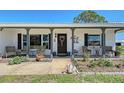 Welcoming front porch with seating, decorative plants, a wreath on the door, and a charming swan statue at 1325 Bottlebrush Dr, Bradenton, FL 34208
