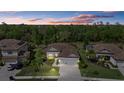 Aerial view of a luxurious home with a tile roof, three car garage, and lush landscaping at 17045 Polo Trl, Bradenton, FL 34211