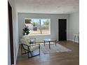 Inviting living space with wood floors, neutral tones, modern chairs, a coffee table, and bright natural light at 2404 Lehigh Ave, Bradenton, FL 34207
