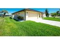 Well-maintained home with a two-car garage, lush green lawn, and meticulous landscaping at 25422 Aysen Dr, Punta Gorda, FL 33983